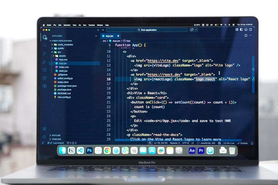 A close-up view of a person's hands working on a laptop computer displaying a coding interface with colorful lines of code. The workspace includes a black mug positioned to the left of the laptop, a s